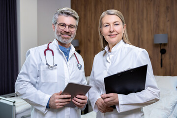 Doctors in lab coats standing close and looking confident