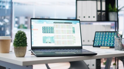 Empty office with stock portfolio on devices containing collection of investment bonds and other financial assets. Real time index indices showing stock demand surge on laptop and tablet