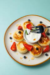 Delicious homemade cheesecakes with fresh strawberries and a dollop of sour cream. Ideal for a healthy and delicious breakfast or dessert. Children's menu. breakfast in a cafe, restaurant