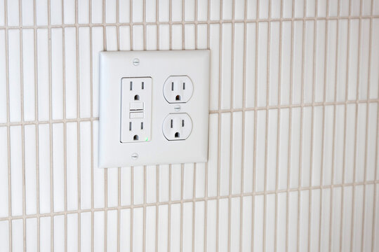 Electrical outlet and GFCI outlet. Duplex outlet mounted on kitchen wall