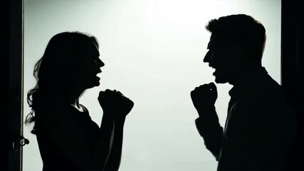 Silhouette of couple fighting each other arguing and yelling at one another Young man and woman shouting in anger Candid behind closed doors