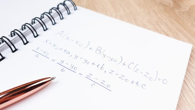 An algebraic equation on a notepad with a pen. Mathematical calculations written in a notebook.