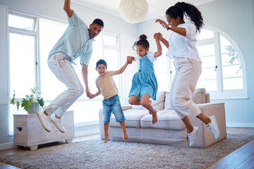 Happy family, jumping and playing with energetic children for bonding, weekend or holiday at home. Mother, father and kids enjoying fun activity in air with parents in living room together at house