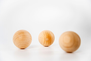 Round wooden balls, spaced apart, app stack on white background, Copy Space
