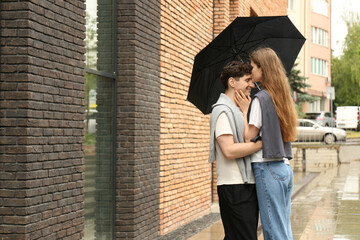 Fototapeta premium International dating. Lovely young couple with umbrella spending time together outdoors, space for text
