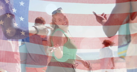 Image of flag of usa over happy diverse friends on beach in summer