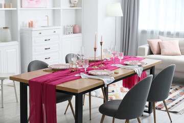 Beautiful table setting with pink accent and chairs in dining room