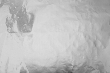 Shiny silver foil as background, top view