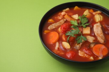 Tasty homemade stew with vegetables on light green table, closeup. Space for text