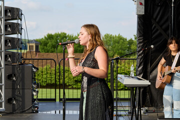 Female performer on stage. Portrait of woman singing at a microphone.