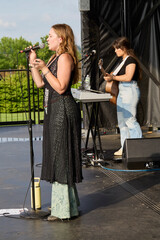 Female performer on stage. Portrait of woman singing at a microphone.