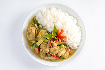 Chicken green curry with coconut shoots over rice  isolated on white background.