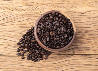 Coffee beans on a bowl over wooden table