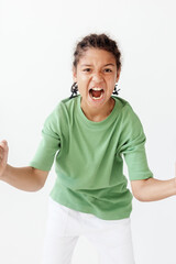 Fototapeta premium Frustrated young boy in green tshirt and white pants makes angry face in trendy style