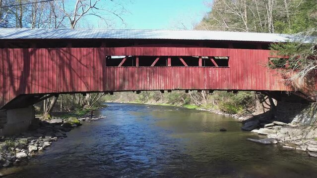 Josiah Hess covered bridge near Orangeville PA. Medium shot of the bridge side, over the stream, that zooms in to closeup of the window openings. Shot on an early Spring day.