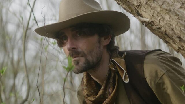 Close up of a wounded cowboy finding his way through wasteland.