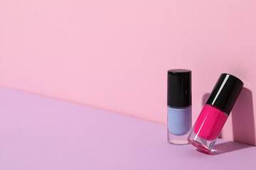Multicolored nail polishes on a pink background