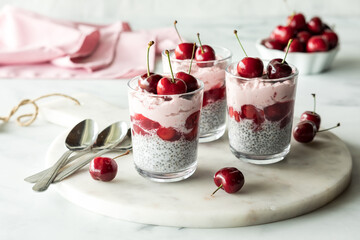 Creamy cherry chia puddings topped with fresh cherries, ready for eating.