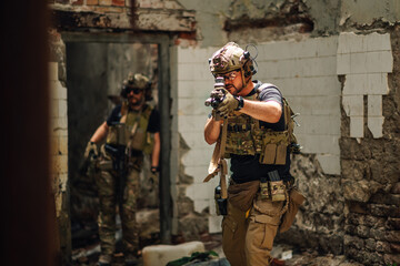 Portrait of brave soldier in ruins shooting towards camera.