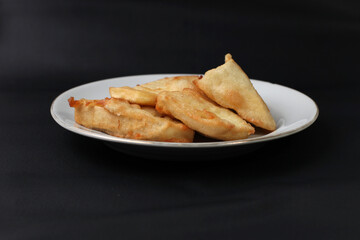 food made from thinly sliced ​​breadfruit coated in a wheat flour mixture then fried until dry and crispy. Fried breadfruit isolated on black background.