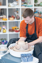 A potter working on a potter's wheel. Vertical photo.