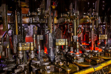 Glass factory, production of glass containers. Molten glass is blown into molds. Robotics in industry. Modern technologies, robotic machines produce products. Technological work at the plant.