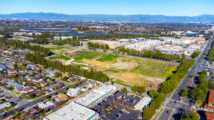 Aerial view of the former site of a demolished shopping mall surrounded by residential and commercial buildings in Cupertino, California