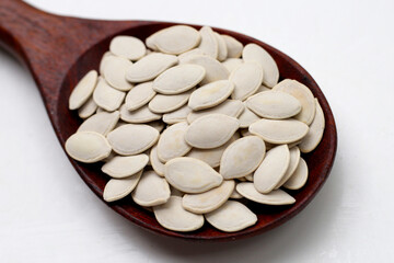 Roasted pumpkin seeds on white background.