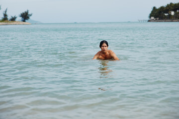 Smiling Asian Man Swimming in the Blue Ocean: Summer Vacation Bliss
