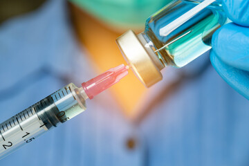 doctor uses a syringe to dispense medication from the bottle. at the hospital. Health and medical...