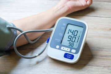 Man checks blood pressure monitor and heart rate monitor with digital pressure gauge. Health care and Medical concept.	
