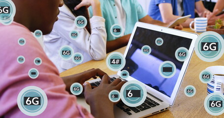 Image of multiple 6g text in circles over african american man working on laptop in office