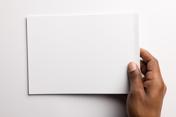 Obraz premium Biracial man holding a blank card, with copy space