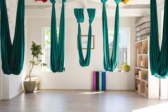 Green gymnastic sashes hanging at aerial yoga gym room