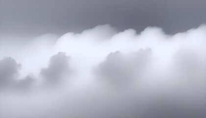 White fluffy clouds float across a gray sky, partially obscuring the sun and creating a hazy, soft appearance