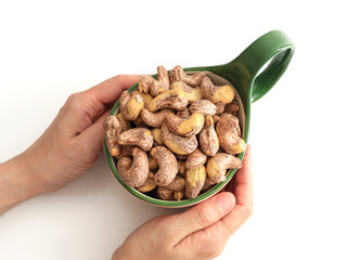 A cup of nut cashews on a white table top