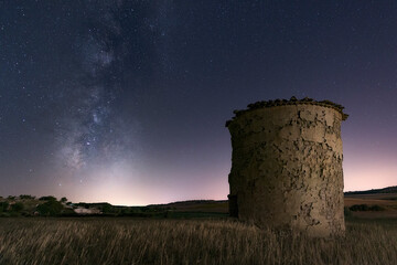 milky way over a cereal field and an old ruined dovecote in El Cerrato, Palencia