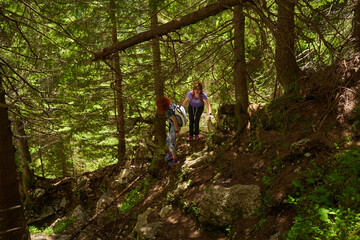 Obraz premium Women with backpacks hiking in the mountains