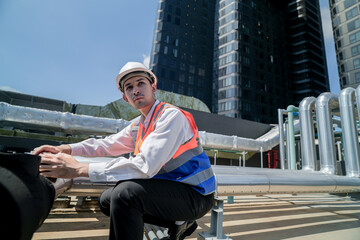 Male engineer inspects air and water pipelines in the engineering system area of ​​the factory...