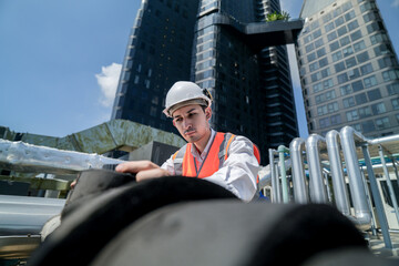 Male engineer inspects air and water pipelines in the engineering system area of ​​the factory...