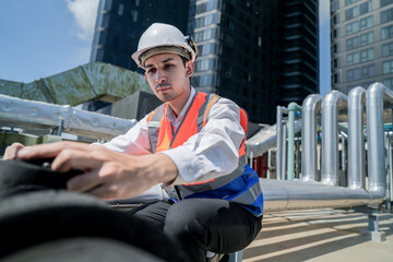 Male engineer inspects air and water pipelines in the engineering system area of ​​the factory...