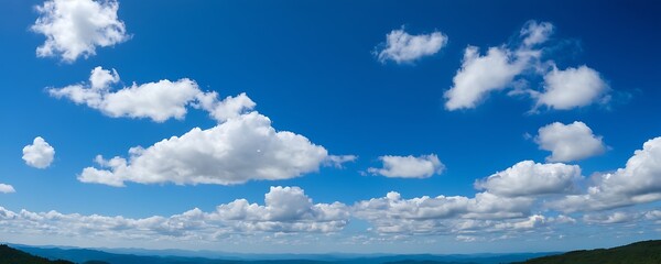 clear blue sky with scattered, fluffy white clouds. The even distribution of the clouds creates a sense of calmness and peace.