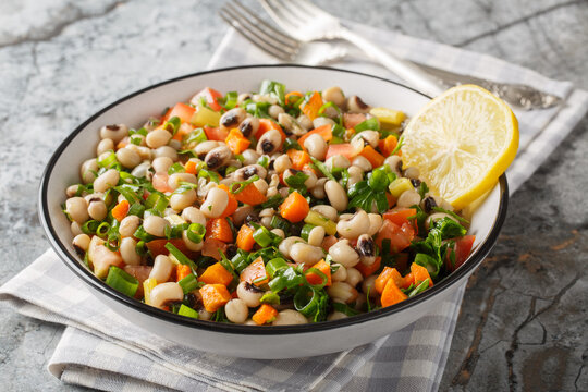 Salad of Mavromatika of Feneos made with black-eyed peas and vegetables closeup on the plate on the table. Horizontal