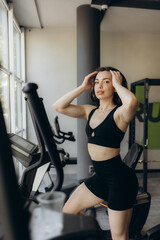 Attractive young woman is working out on an elliptical trainer in gym