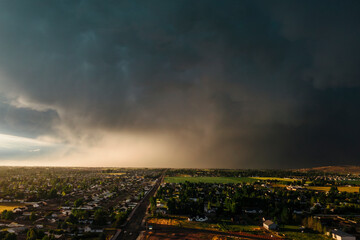 Dramatic storm clouds sweep across the sky at sunset.