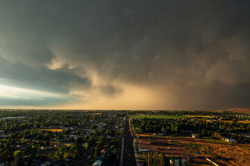 Dramatic storm clouds sweep across the sky at sunset.