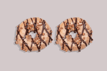 Two chocolate donuts on grey background