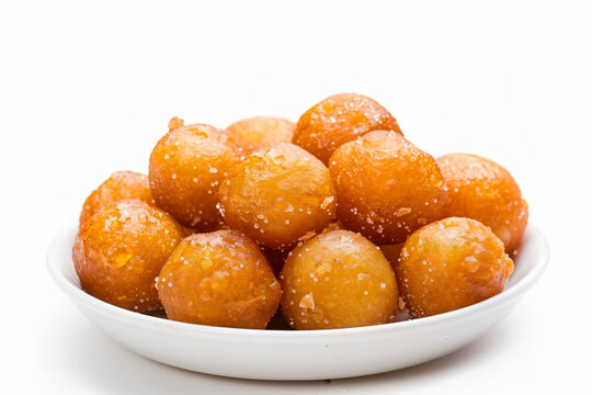 a bowl of sugared donuts on a white surface