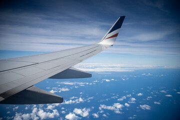 looking out plane window at the clouds above australia over the wing