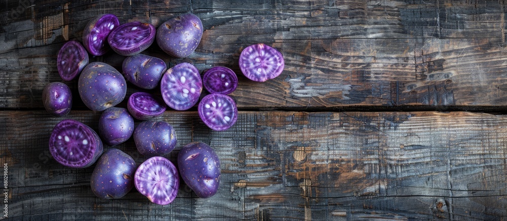 Aufkleber top view of vibrant purple potatoes on rustic wood surface with ample copy space image.